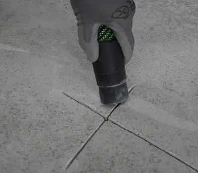 Stof en losse delen met de mobiele stofzuiger uit de scheuren verwijderen