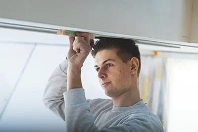 Een medewerker van Stelzle gebruikt de aanzethulp om de geleiderail te verschuiven