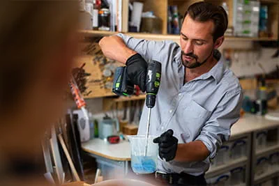 Richard gebruikt een accuboormachine om de hars te roeren die hij voor zijn kunst gebruikt