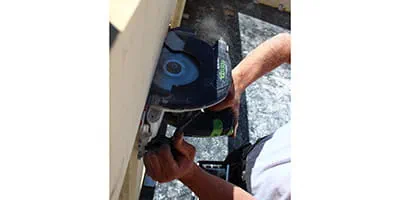 De accu-handcirkelzaag HKC 55 van Festool in actie bij een massief houten huis.