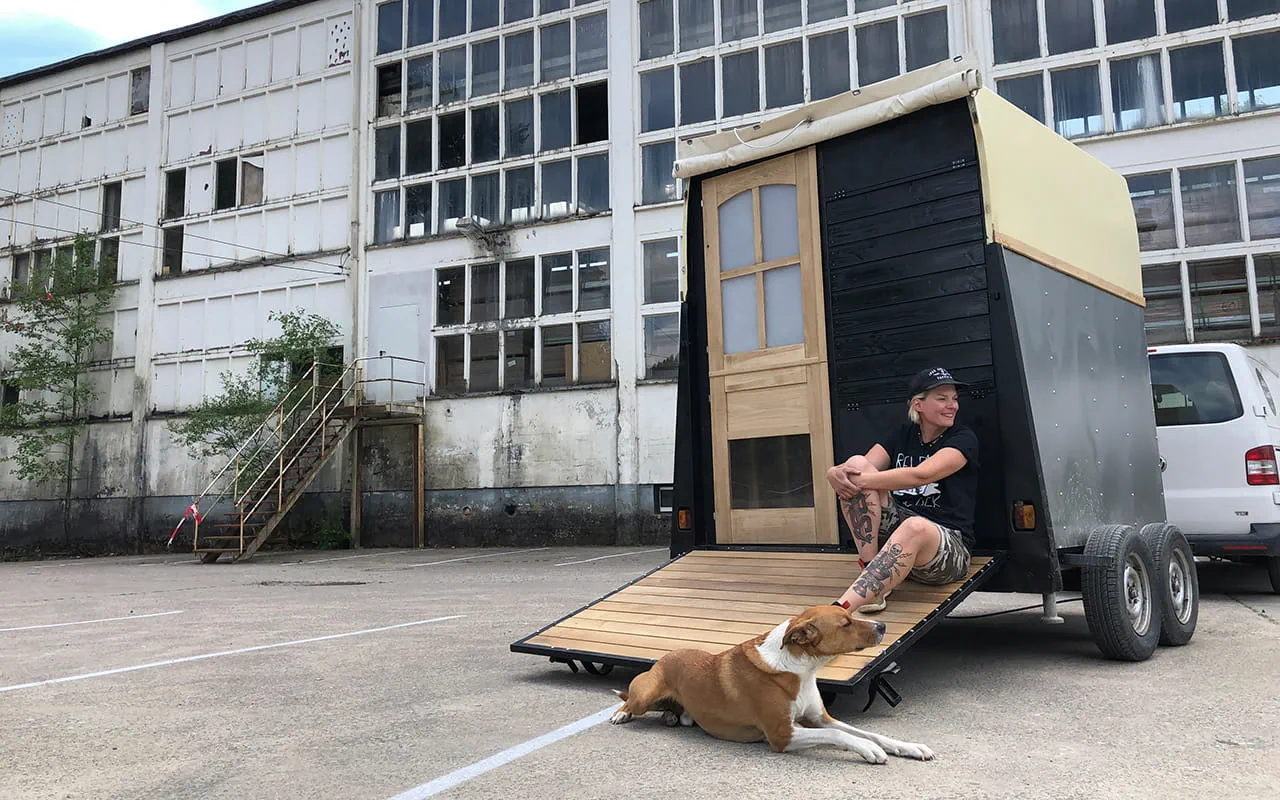 Maker Laura Kampf zit op een trailer met haar hond Smudo.