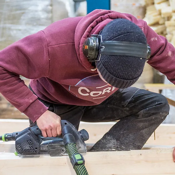 De houten balken worden bewerkt met de Festool eenhandschaaf